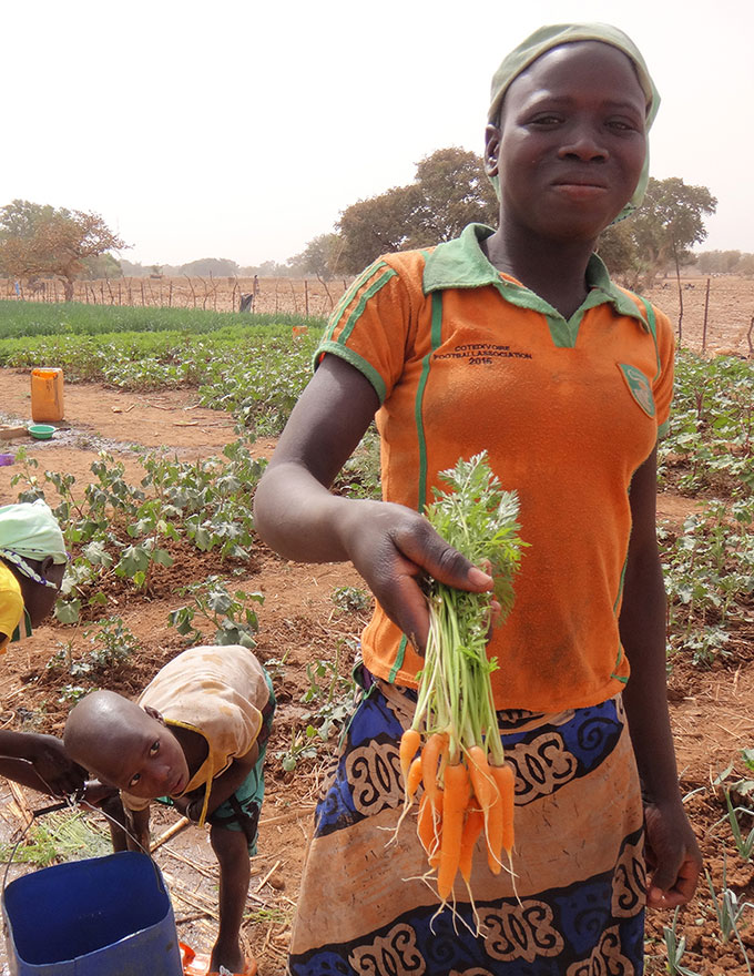 A girl from Bassieri showing her carrots