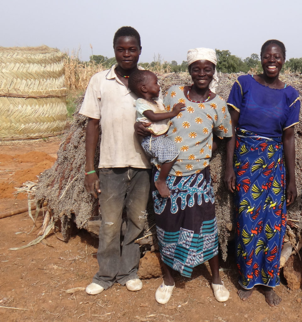 Lankoande Francois's family with sorghum harvest.